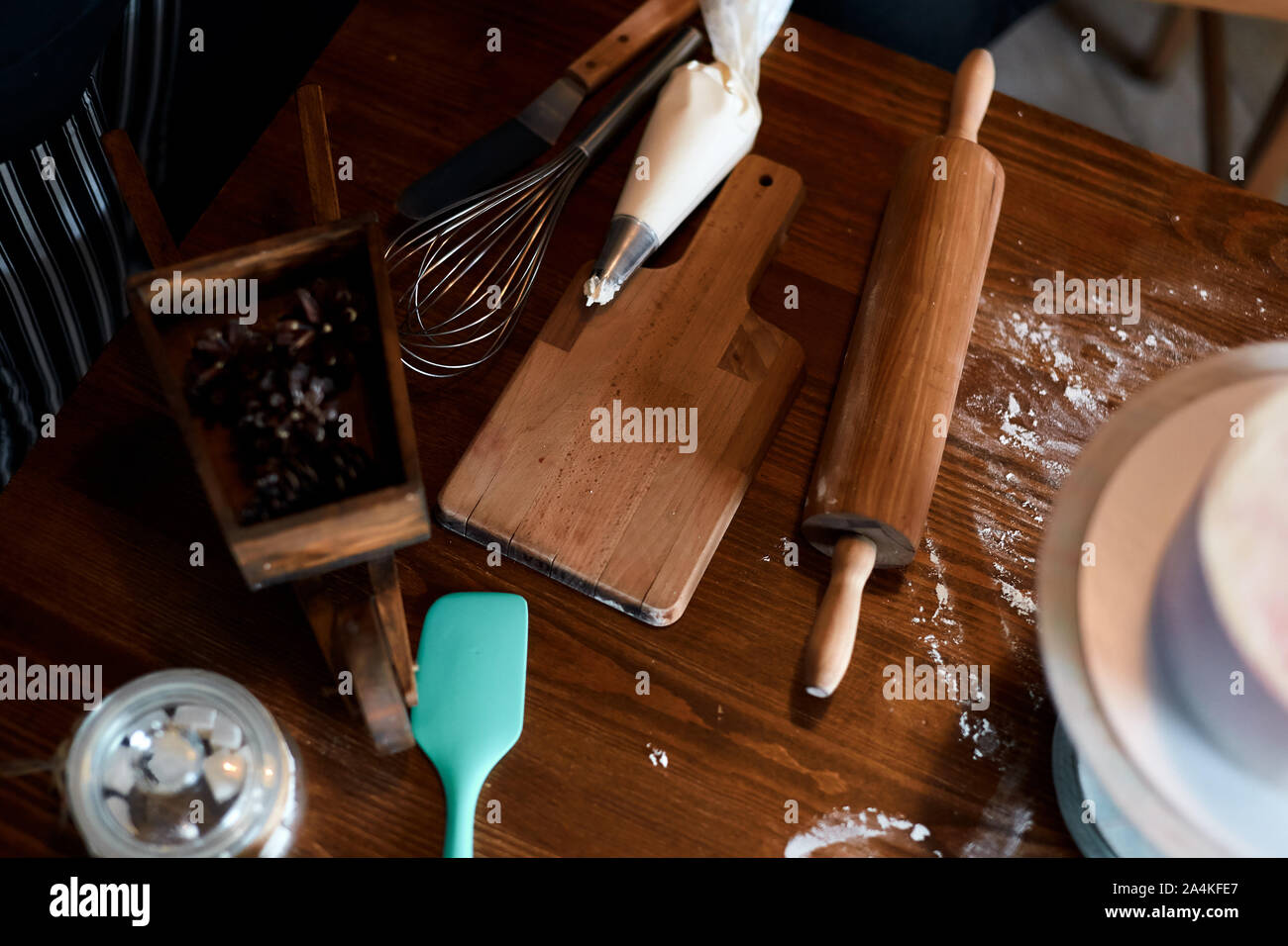 Wooden cutting board , rolling pin, pastry bag on the table in the kitchen, useful tools for baking, cooking cake. Stock Photo