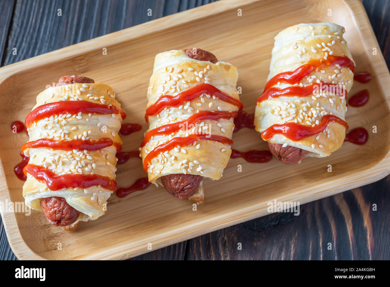 Sausage rolls on the wooden tray: top view Stock Photo