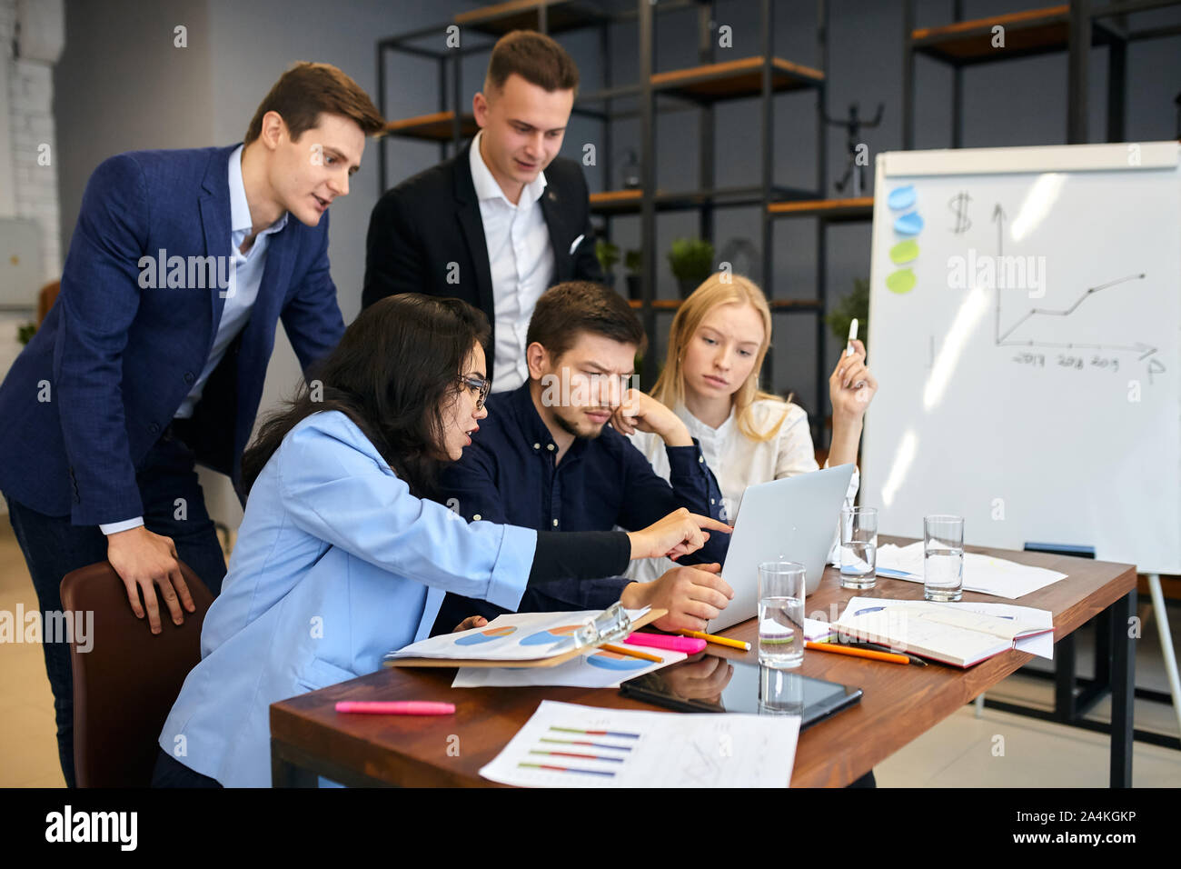 young office workers using laptop at workplace. close up photo. young motivated people pointing at the screen, looking for clients, making advertismen Stock Photo