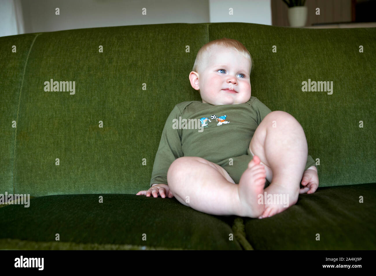 Baby on green couch Stock Photo