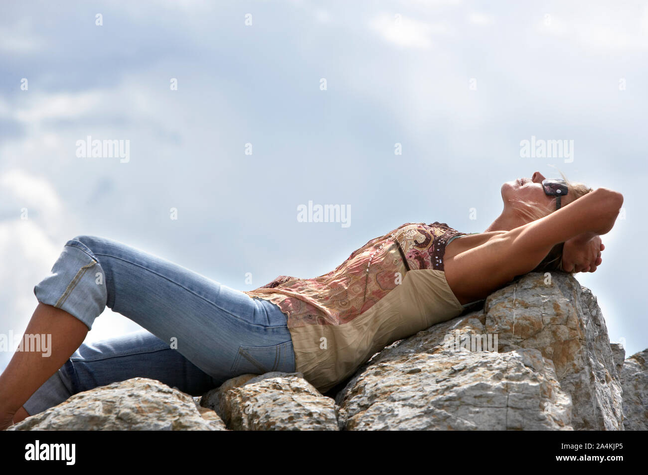 Woman resting on rocks hi-res stock photography and images - Alamy