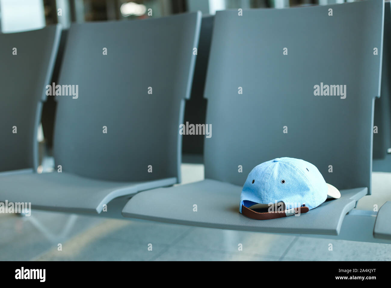 Single jeans cap on grey chairs. Stock Photo