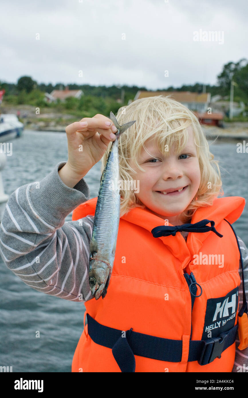 Portrait of child holding mackerel Stock Photo Alamy