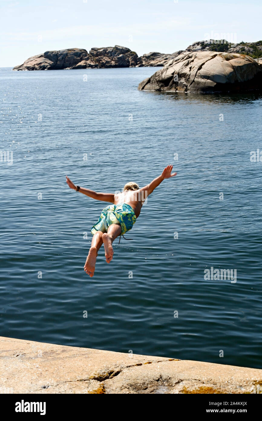 Young man diving from cliff, Vestfold, Norway Stock Photo Alamy