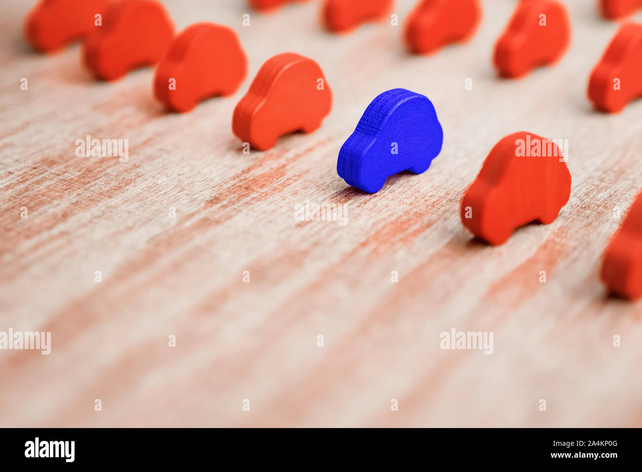 Standing out from crowd. One object differs from others. Equal opportunities. Think different idea. Competition, rivalry background. Toy cars in the range on wooden background. Business concept Stock Photo