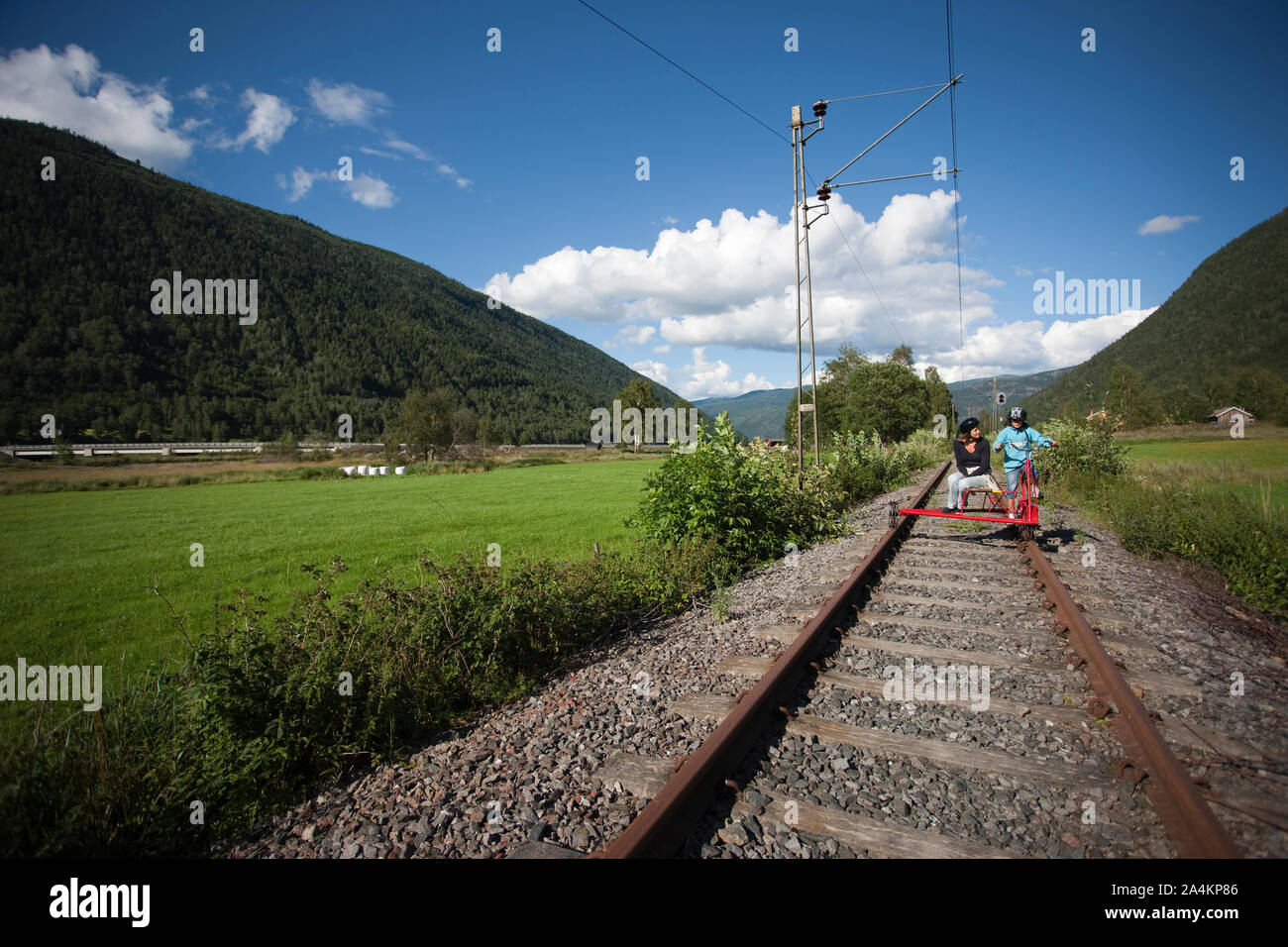 Mother and daughter driving 'dressin' - small carriage - on old railway track, Rjukan, Norway Stock Photo