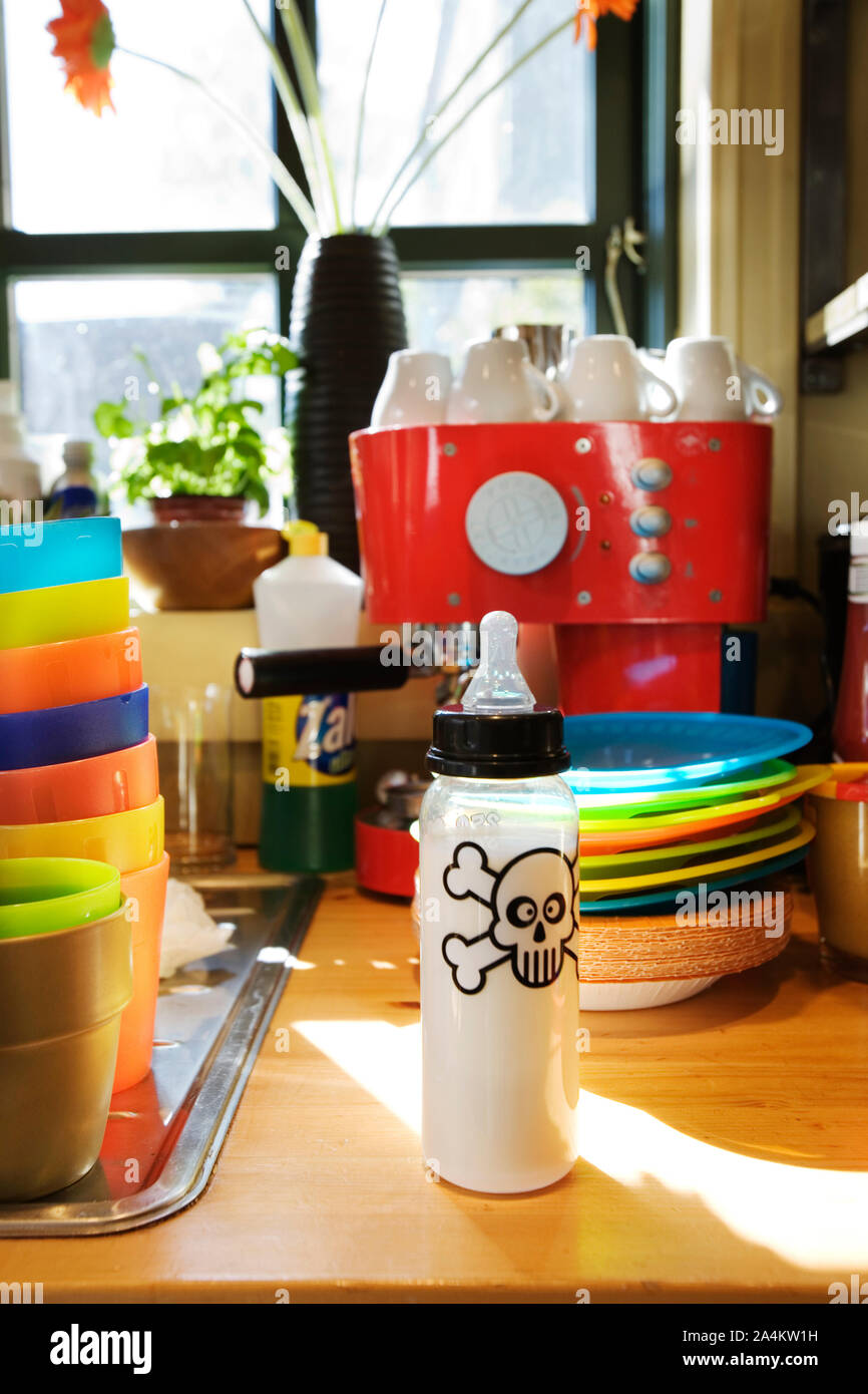 Washing dishes after children's party. Colourful plastic glasses and plates. Stock Photo