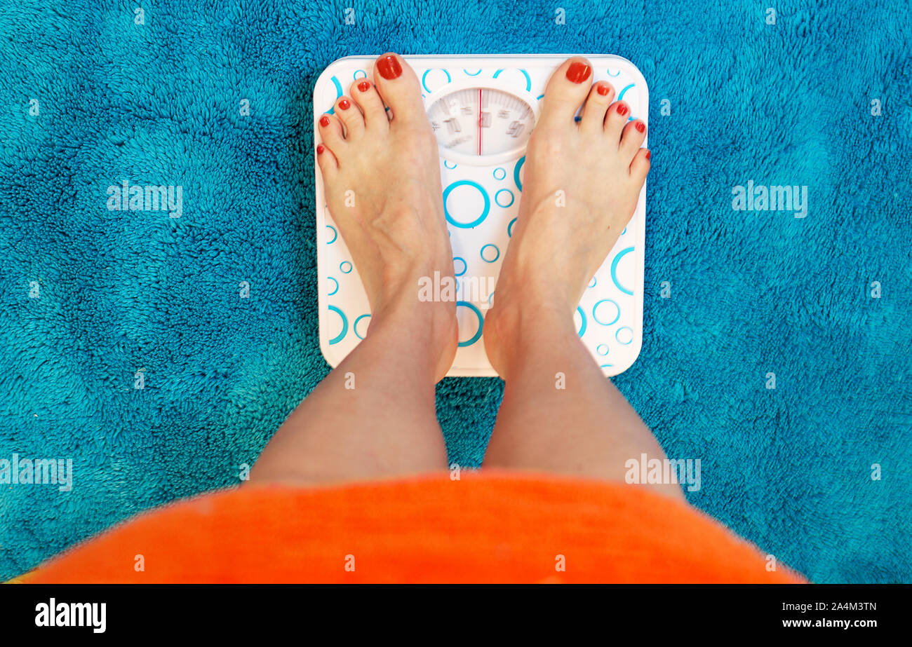 Standing on bathroom scale weight Stock Photo Alamy