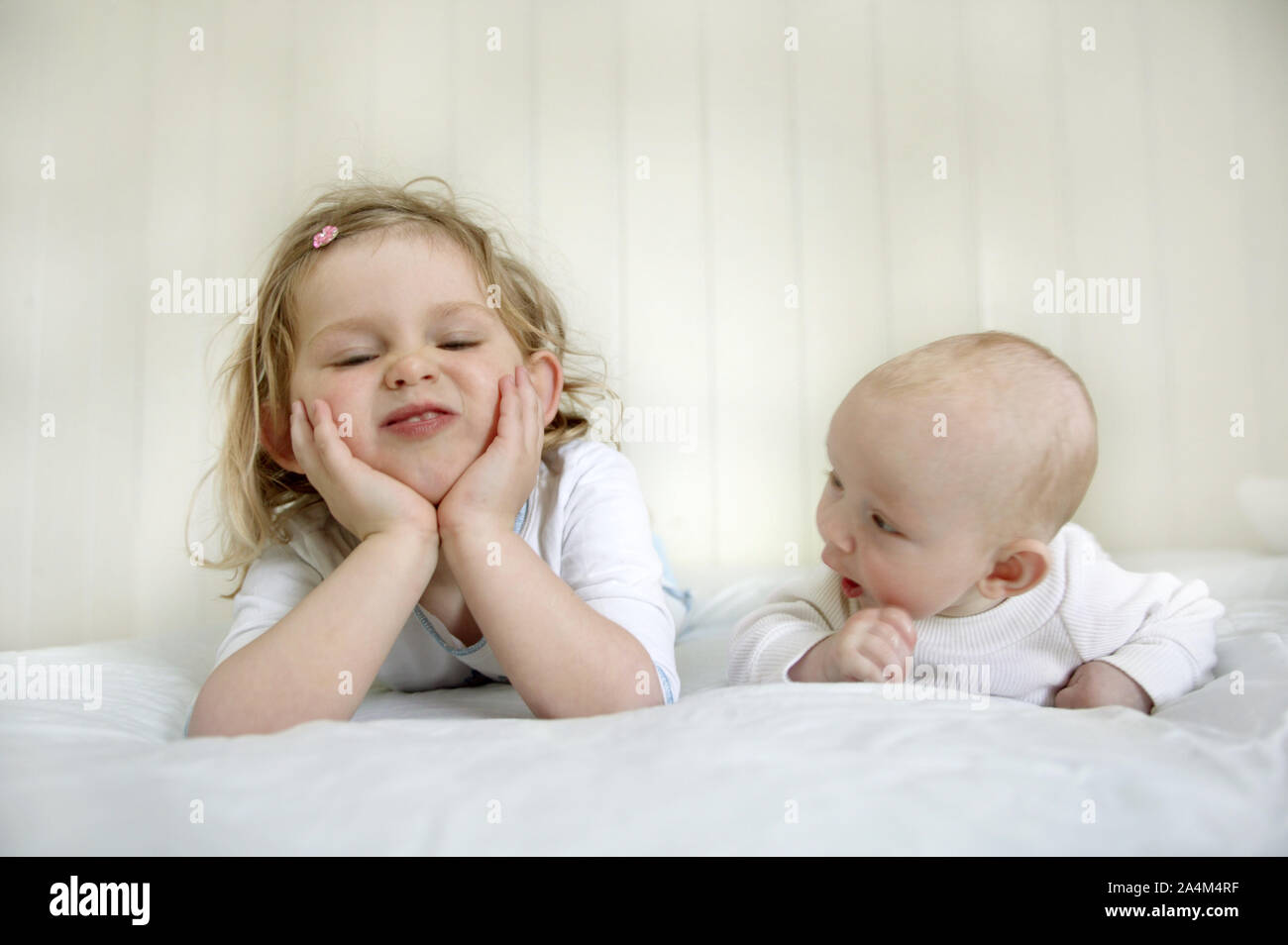 Girl with baby in bed Stock Photo
