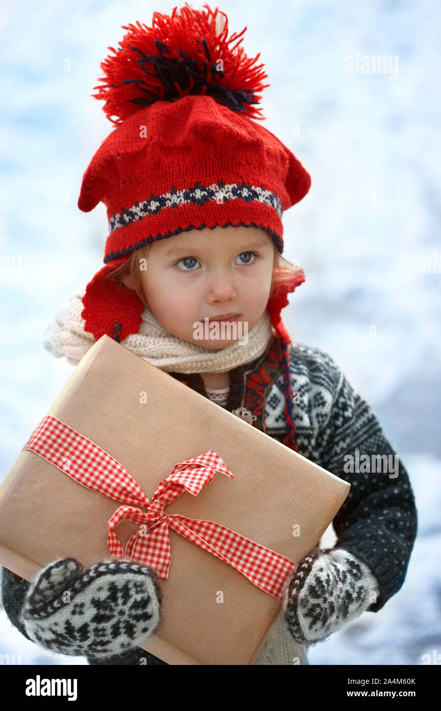 Girl holding a christmas present. Stock Photo