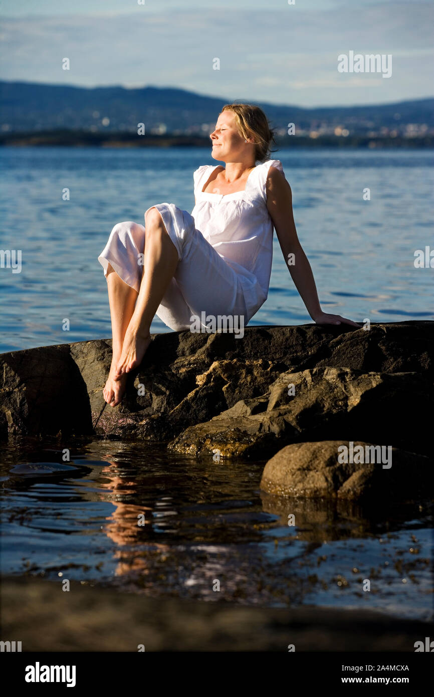 Woman sitting by the sea - relaxing Stock Photo - Alamy
