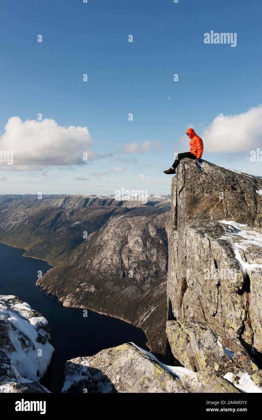 Man Sitting On Edge Of Mountain - Kjerag, Lysefjorden, Ryfylke, Rogaland, Stock Photo