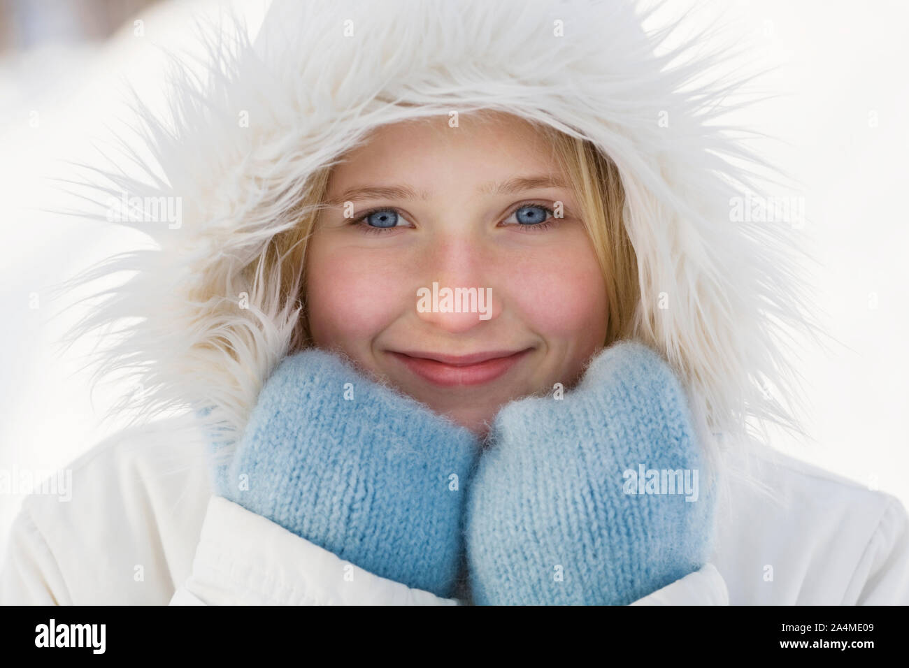 Girl wearing white overcoat with hood and blue mittens Stock Photo - Alamy