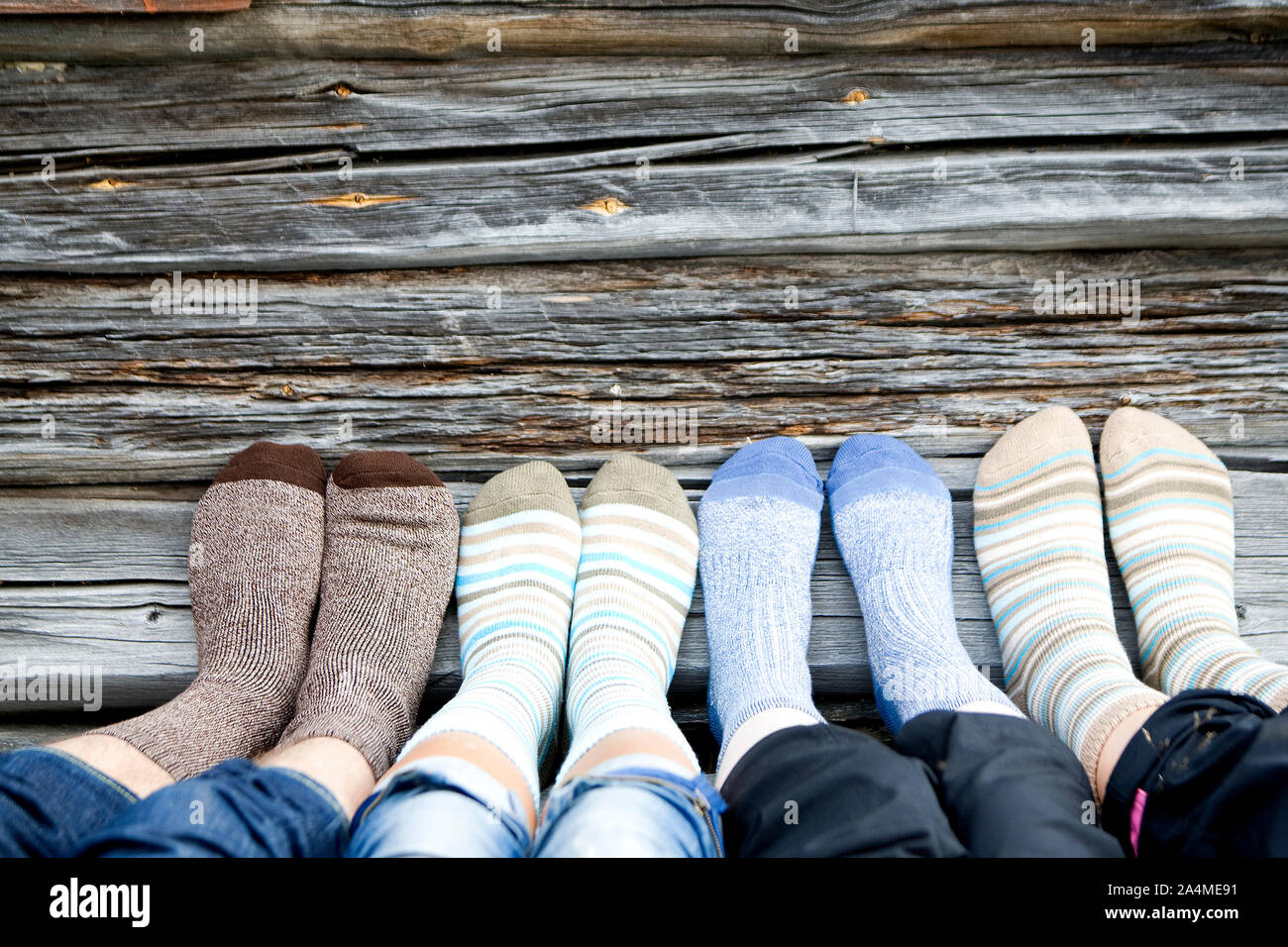 Feet In Assortment Of Socks On Wood Stock Photo