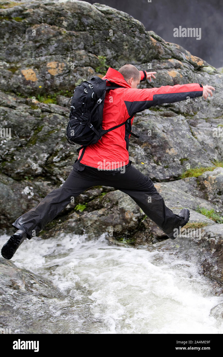 Portrait Of Man Leaping Over Water Stock Photo