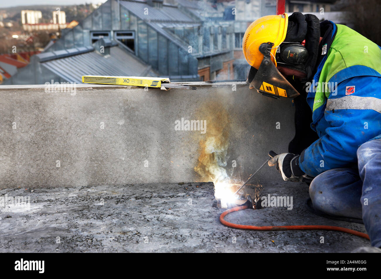Man in safety equipment welding on roof Stock Photo Alamy