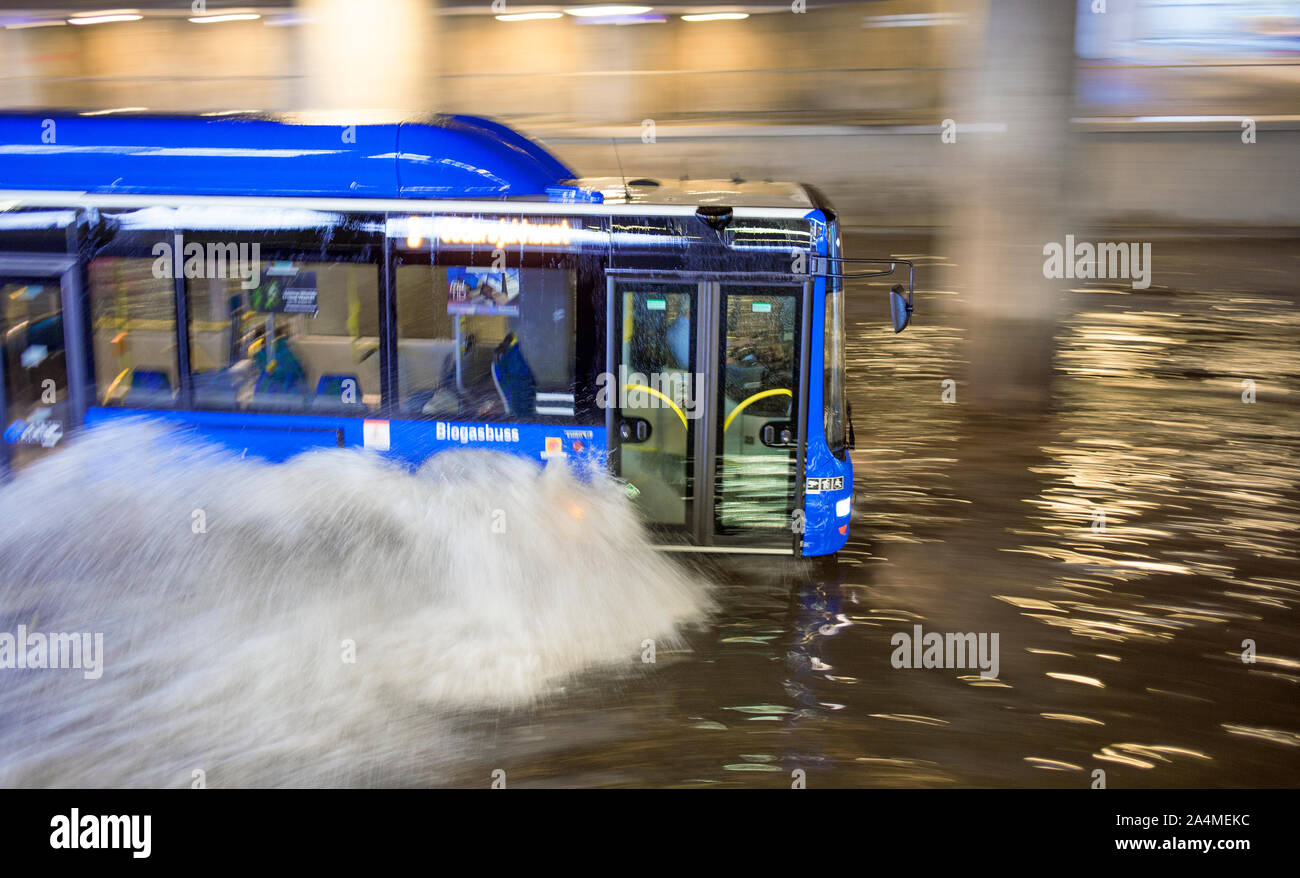 Bus driving through flooded street Stock Photo