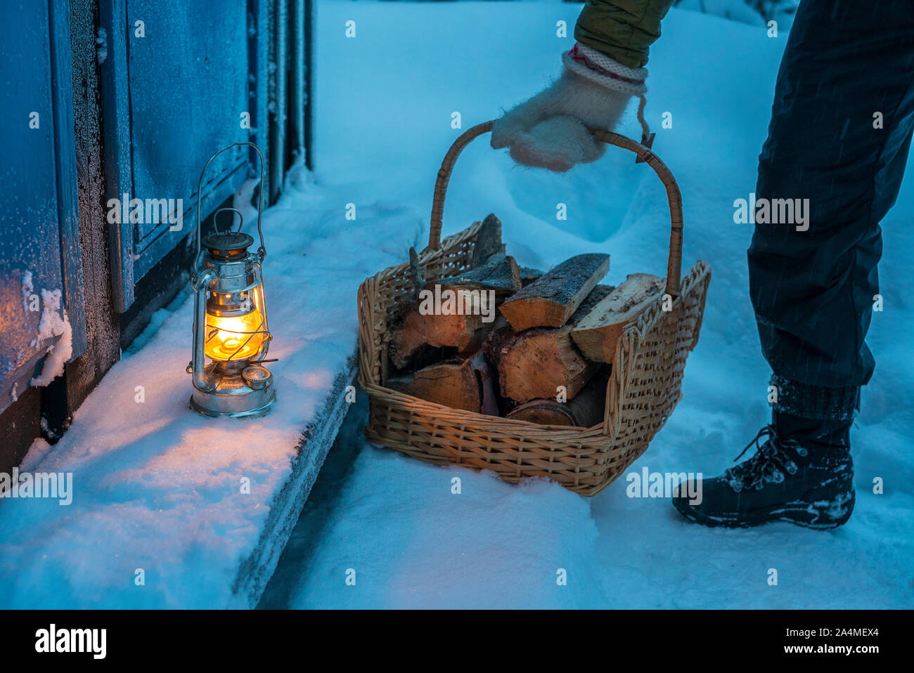 Man with firewood in basket Stock Photo