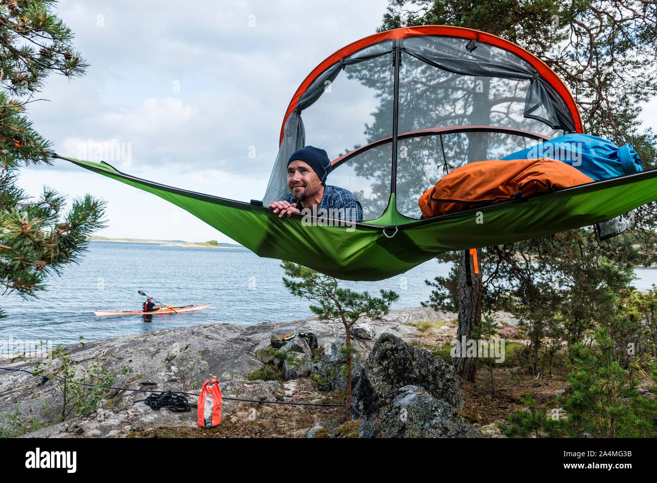 Man resting in hammock at lakeshore Stock Photo