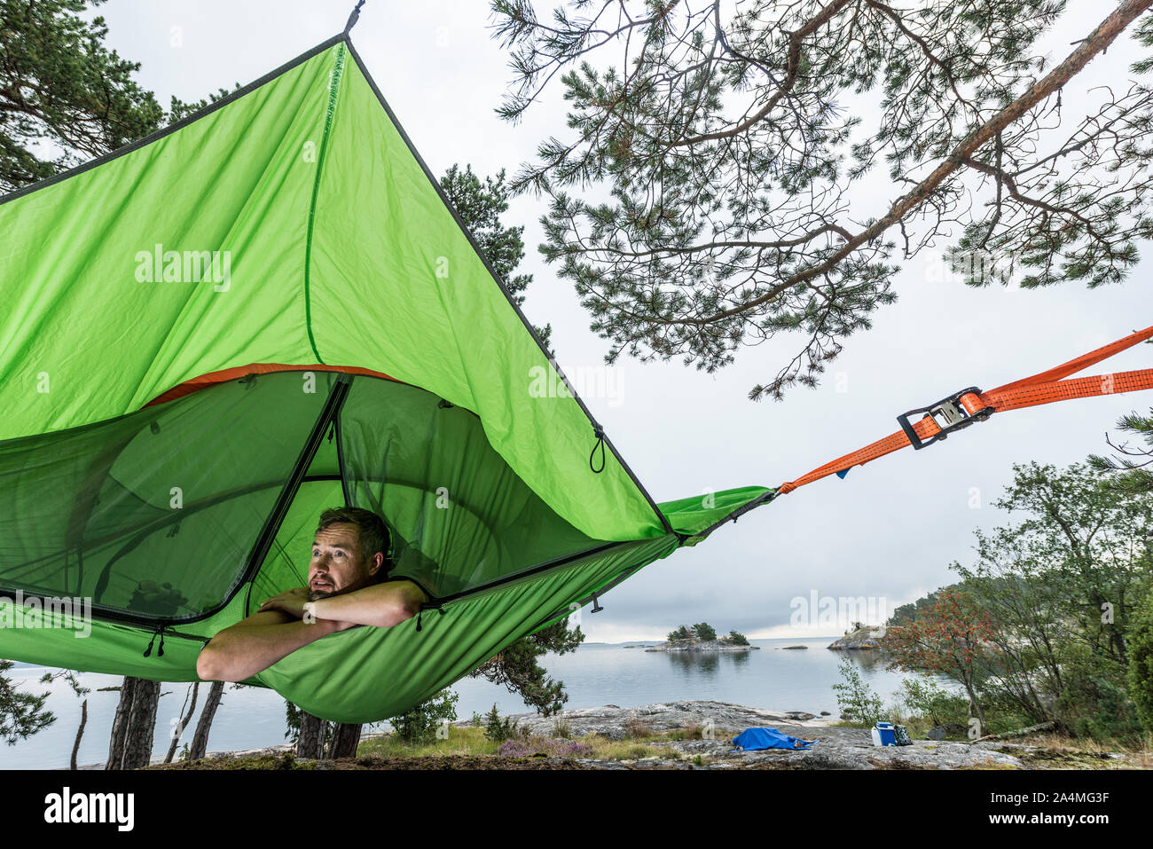 Man resting in hammock at lakeshore Stock Photo