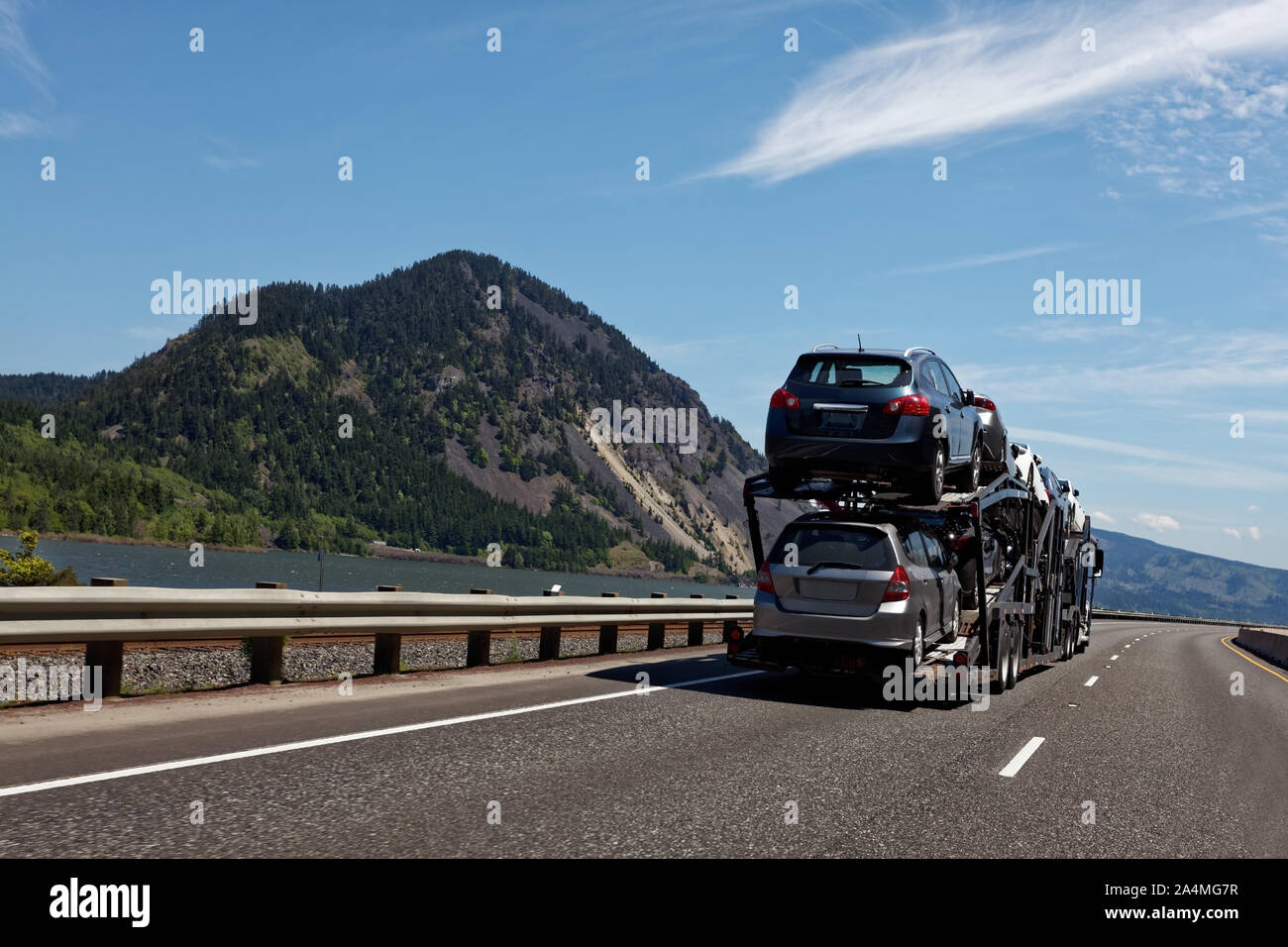 New vehicles being transported to dealerships. Stock Photo