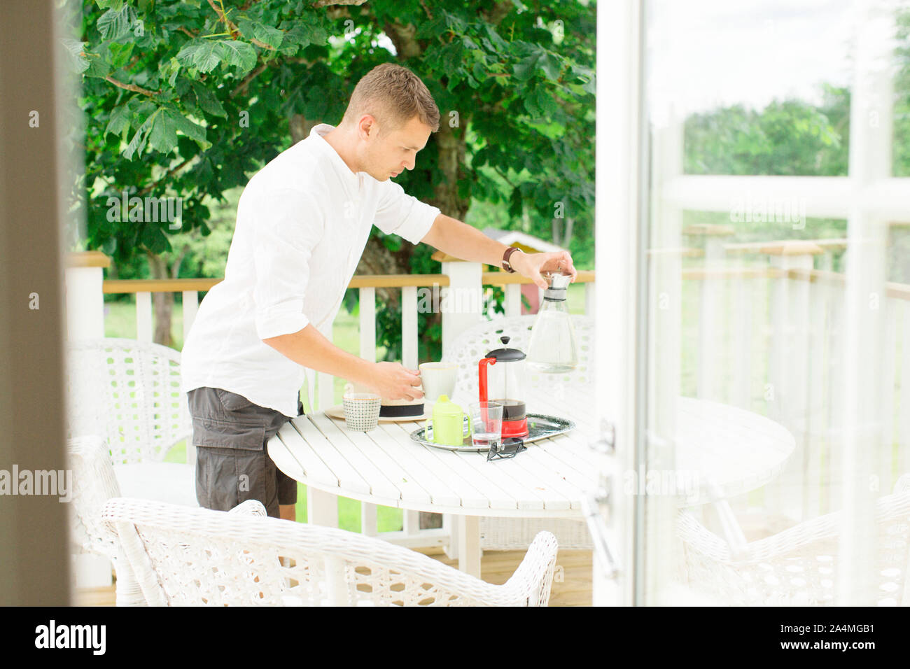 Man preparing coffee on balcony Stock Photo