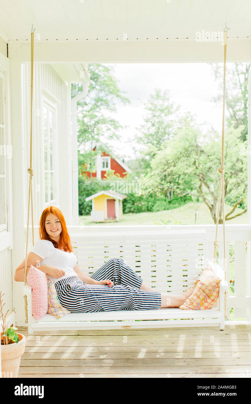 Woman sitting on swing in hi-res stock photography and images - Alamy