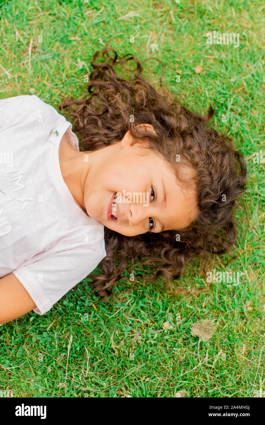 Portrait of girl lying on grass Stock Photo - Alamy