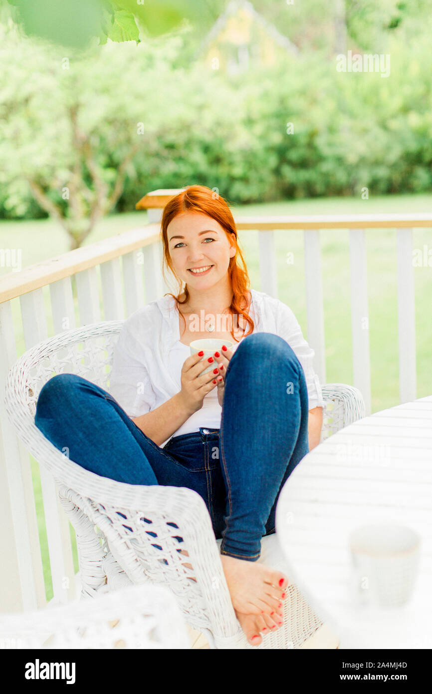 Young woman resting on balcony Stock Photo