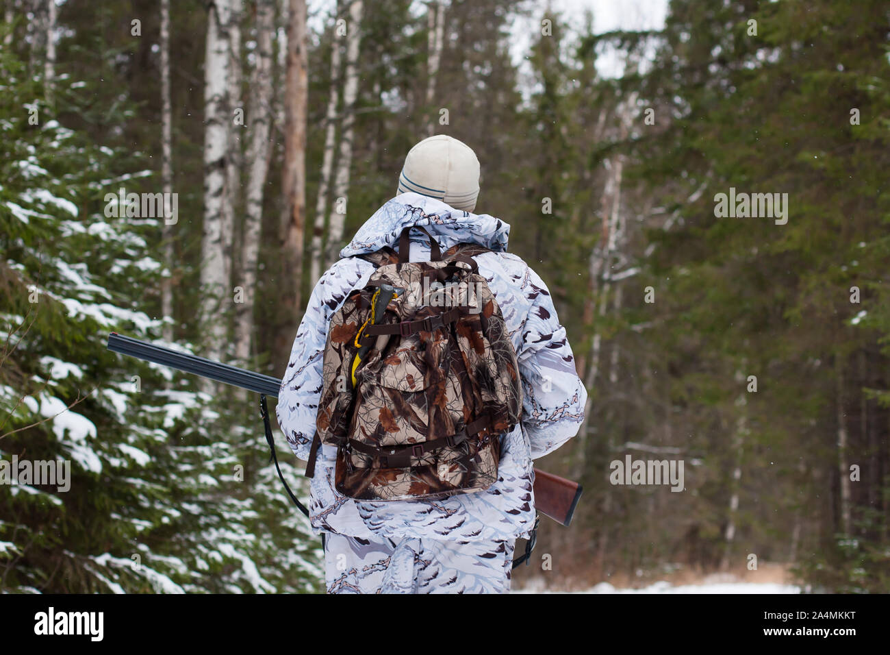 hunter with gun walking in the winter forest Stock Photo