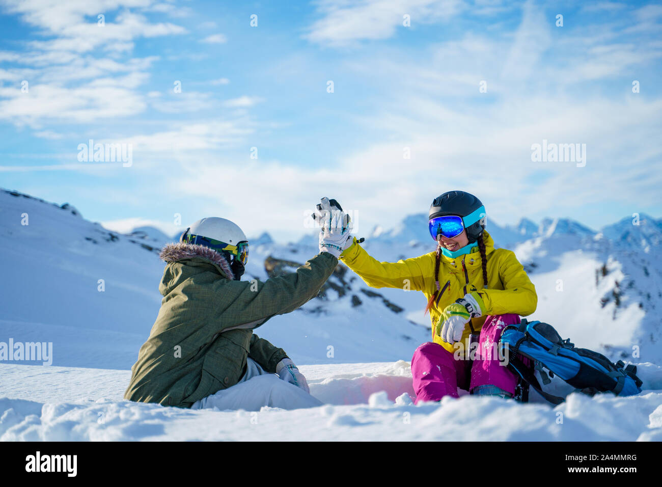 Photo of two sportsmen doing handshake sitting on snow resort in ...
