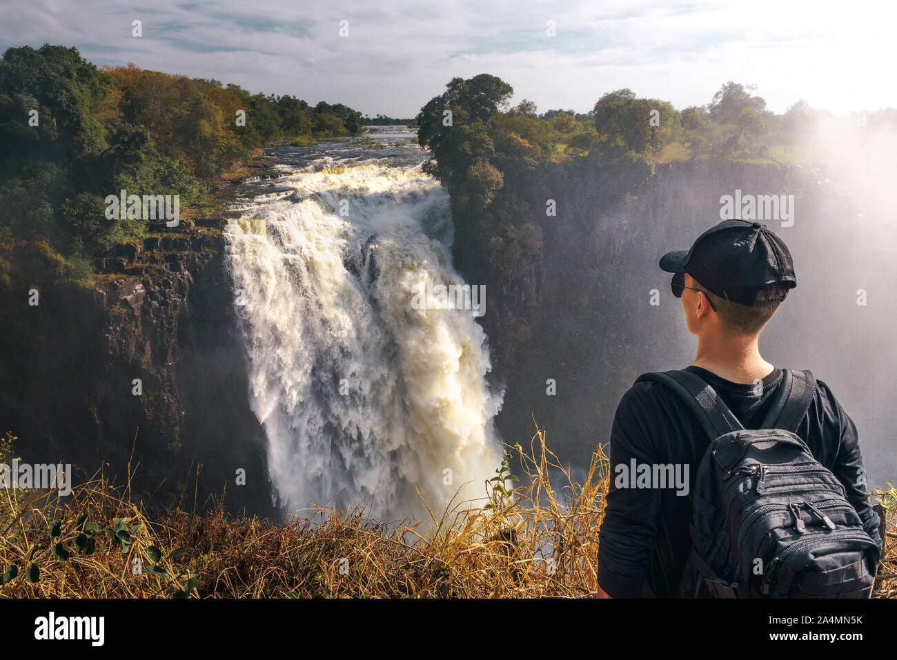 Tourist looks at the Victoria Falls on Zambezi River in Zimbabwe Stock Photo