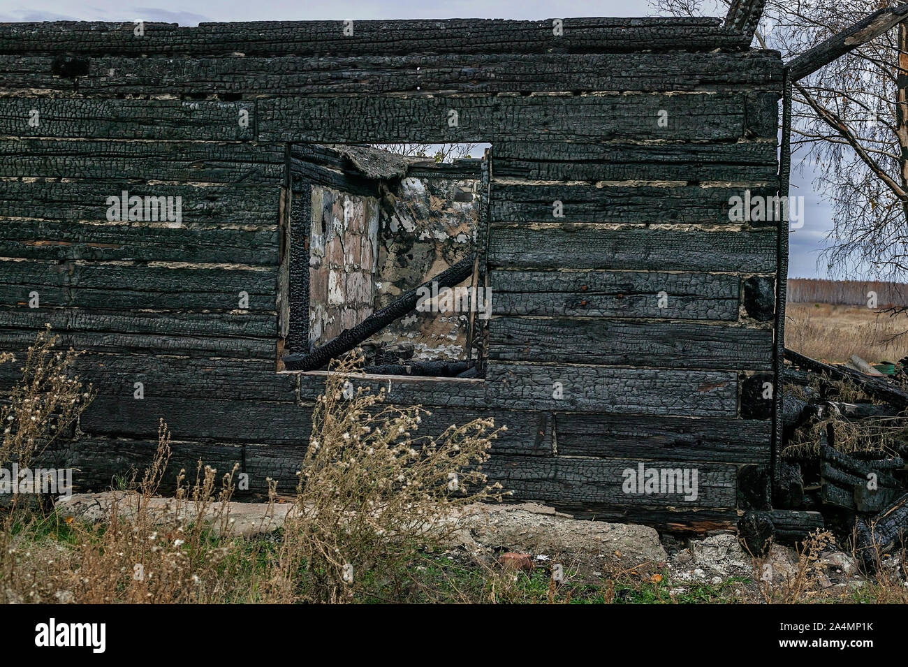 Burnt wooden house. Destroyed roof and windows, charred walls. Horizontal shot Stock Photo