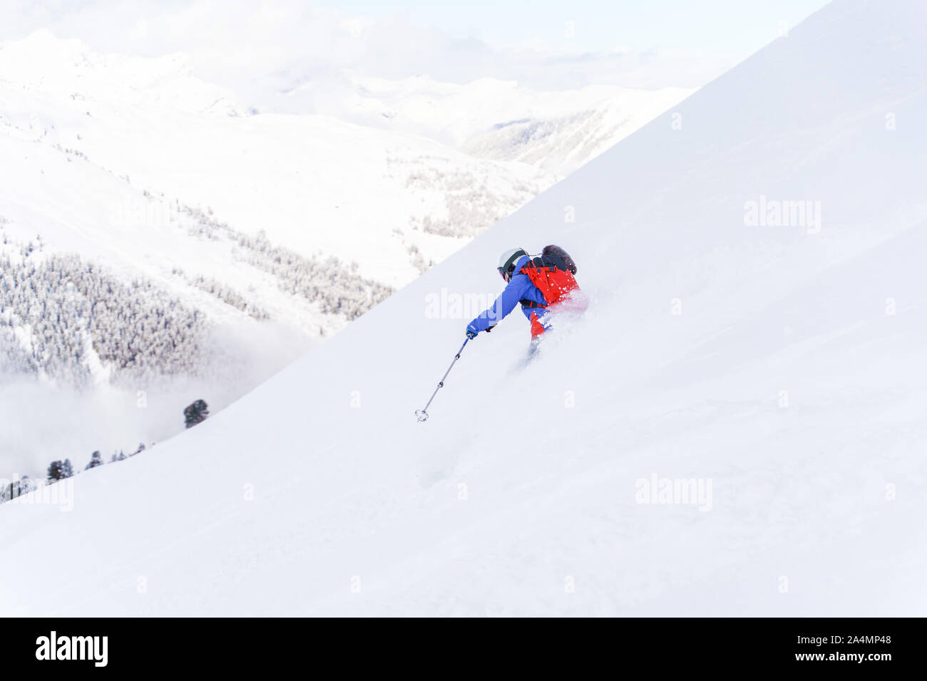 Photo from back of sportsman with backpack skiing in winter resort