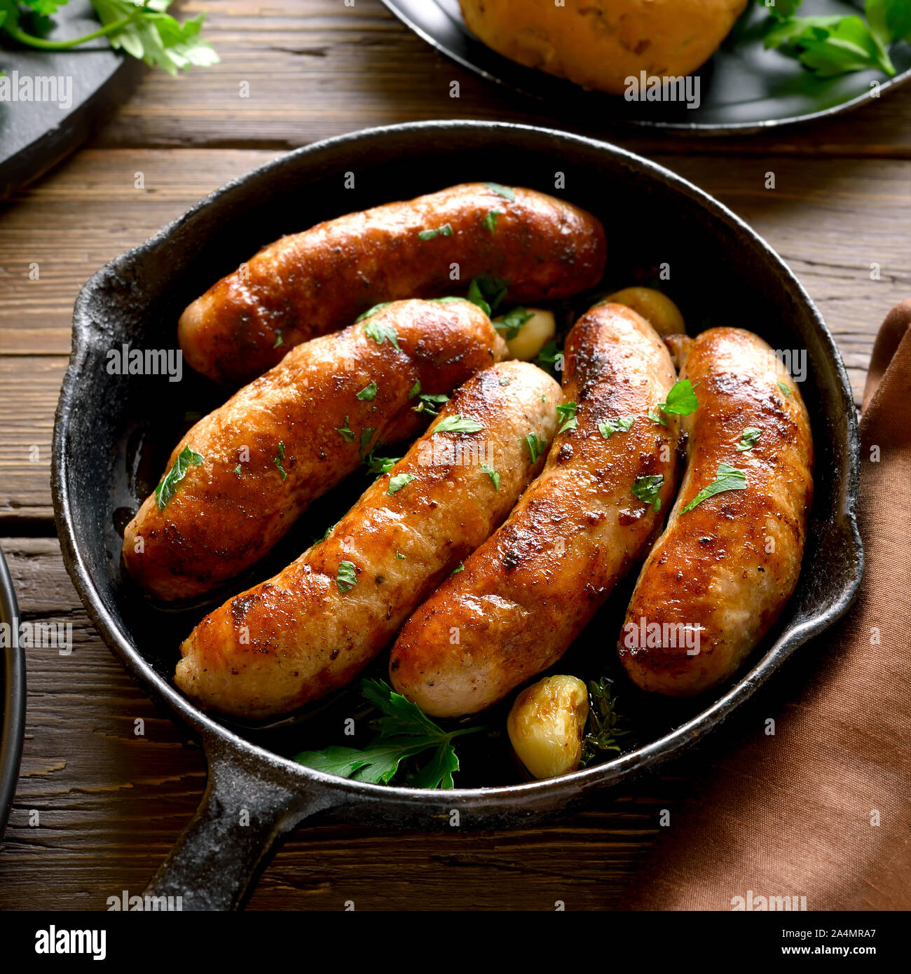Roasted sausages in frying pan over wooden background Stock Photo Alamy