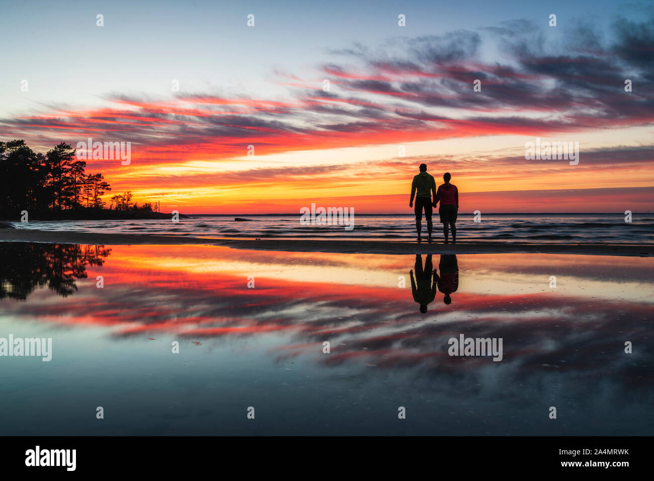 Couple on beach at sunset Stock Photo