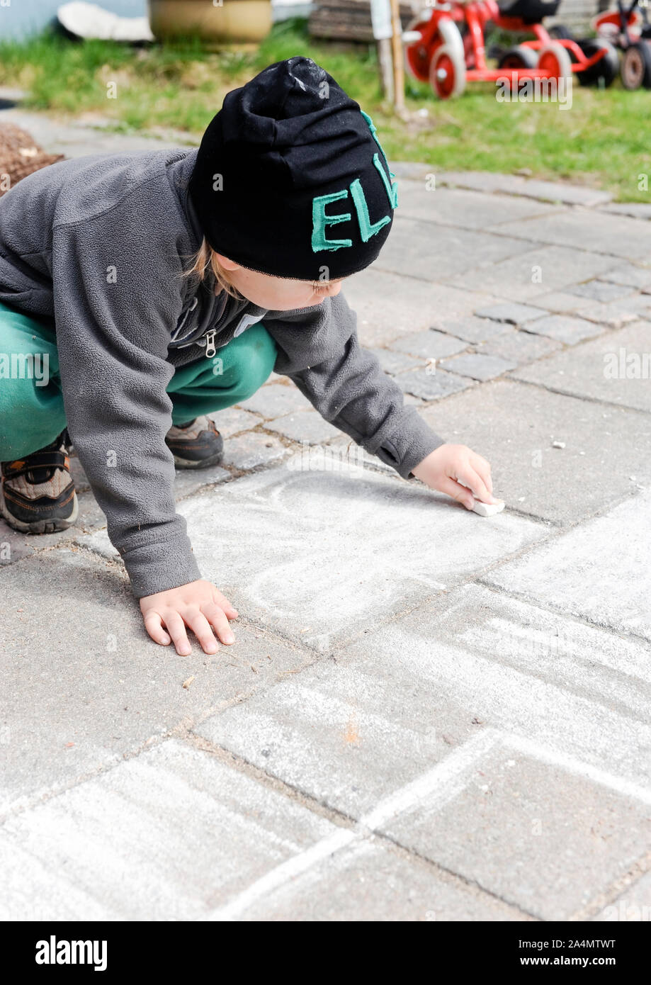 Boy drawing with chalk on pavement Stock Photo - Alamy