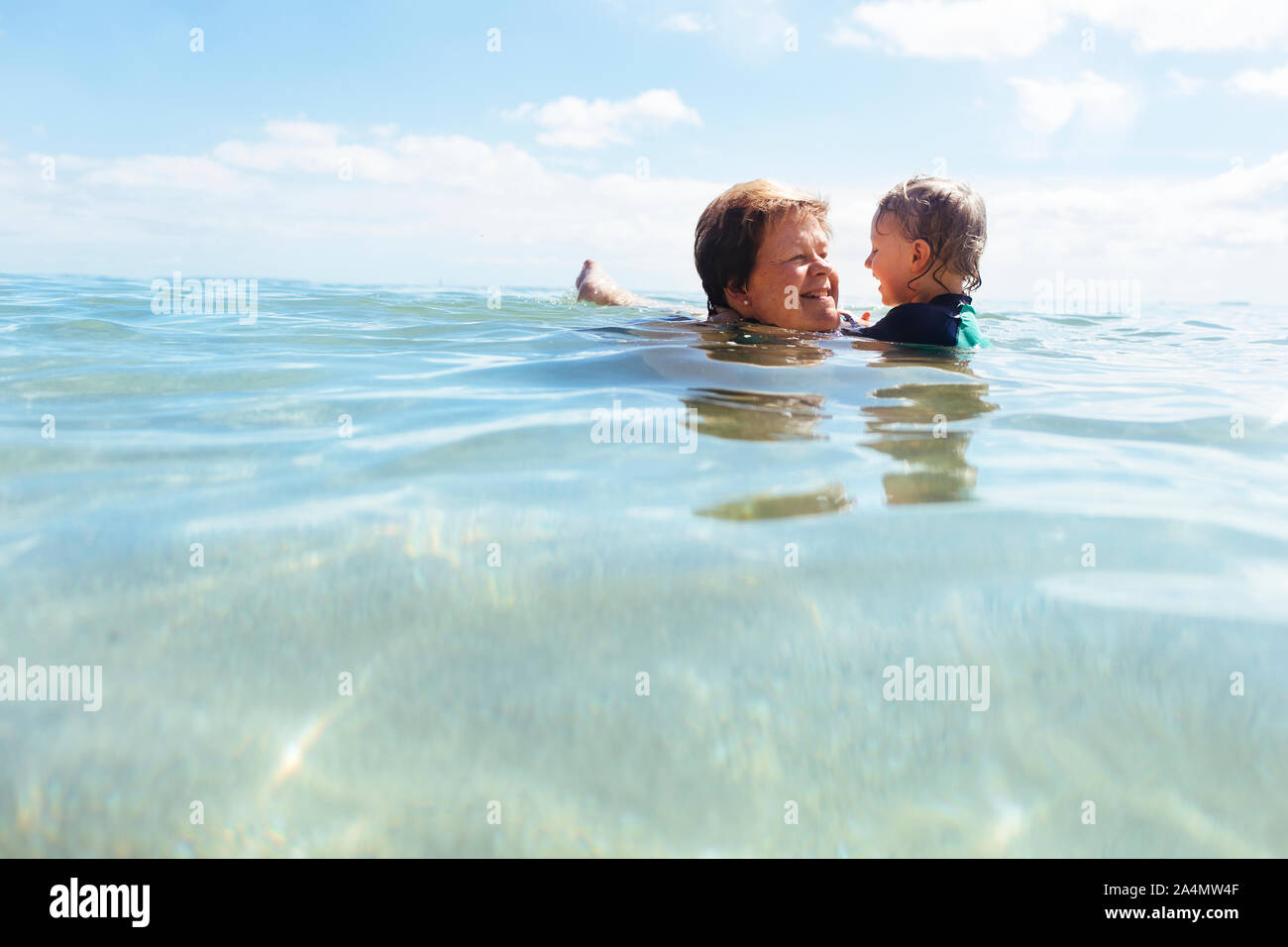 Grandmother swimming with grandson Stock Photo