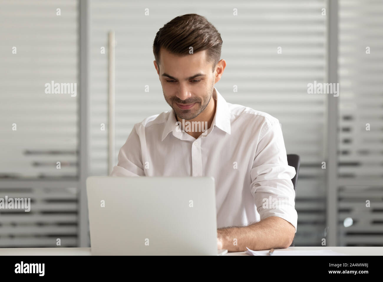 Focused businessman using laptop, busy employee working on project Stock Photo
