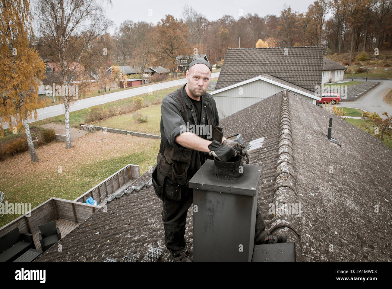 Chimney sweep on roof Stock Photo
