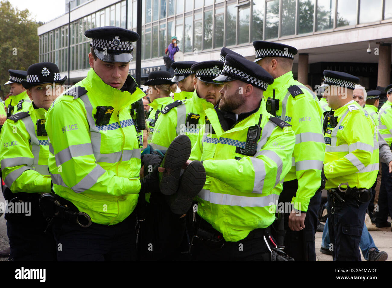 Police made mass arrests as Extinction Rebellion activists defied a London-wide ban on public protests this morning to close off Millbank outside the offices of MI5. Protesting about the lack of food security possible if climate change isn't averted, they parked a caravan in the road and staged a sit in with singing and picnics. Stock Photo