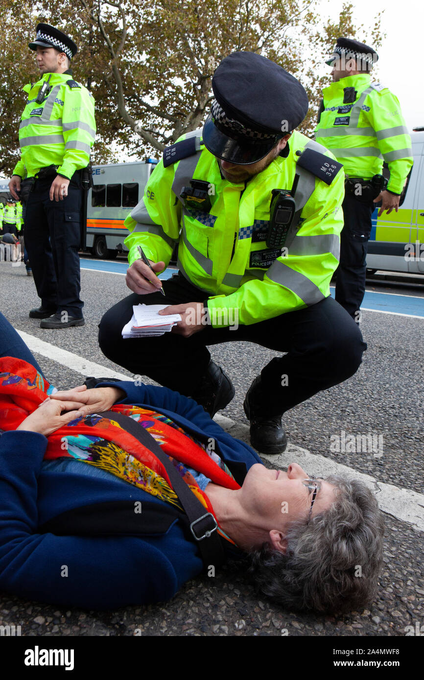 Police made mass arrests as Extinction Rebellion activists defied a London-wide ban on public protests this morning to close off Millbank outside the offices of MI5. Protesting about the lack of food security possible if climate change isn't averted, they parked a caravan in the road and staged a sit in with singing and picnics. Stock Photo