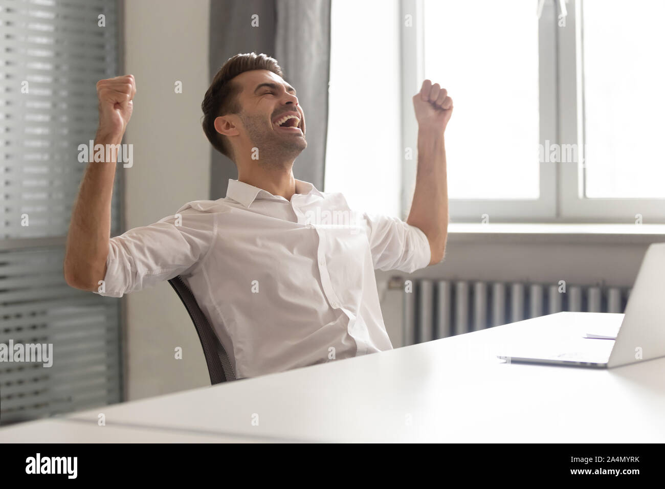 Excited businessman celebrating business success achievement, shouting Stock Photo