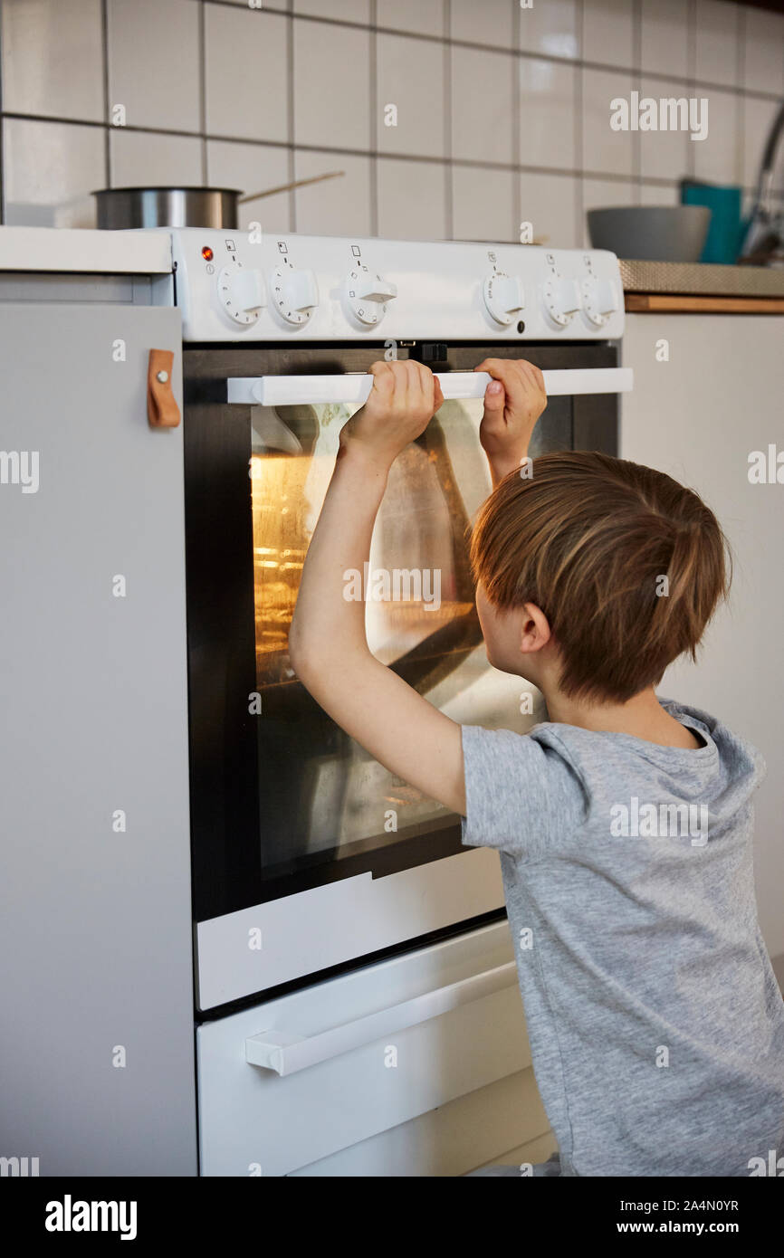 Boy looking into oven Stock Photo Alamy