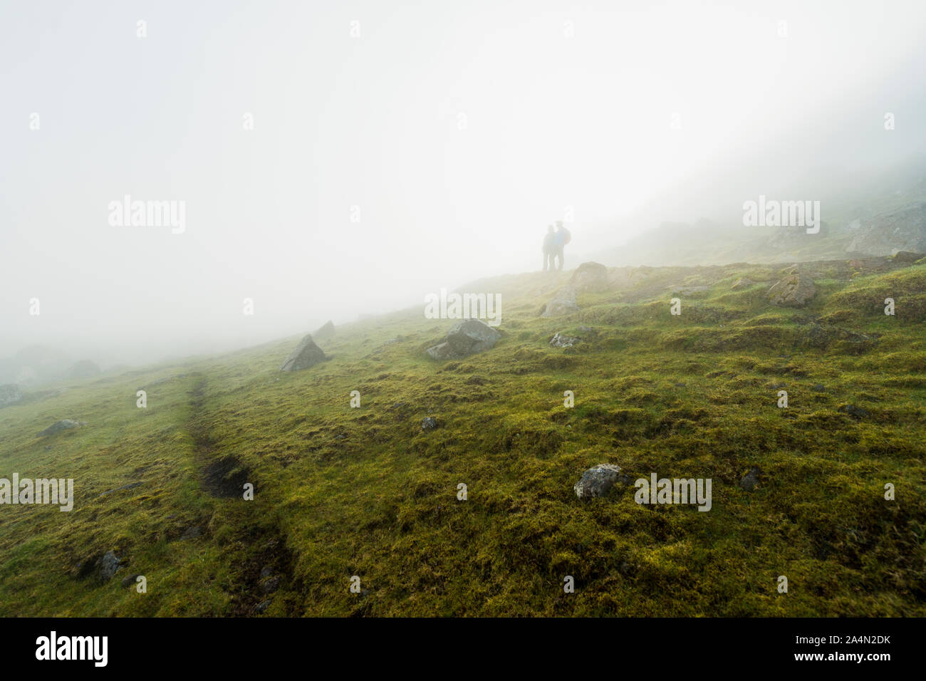 Silhouettes of hikers in fog Stock Photo