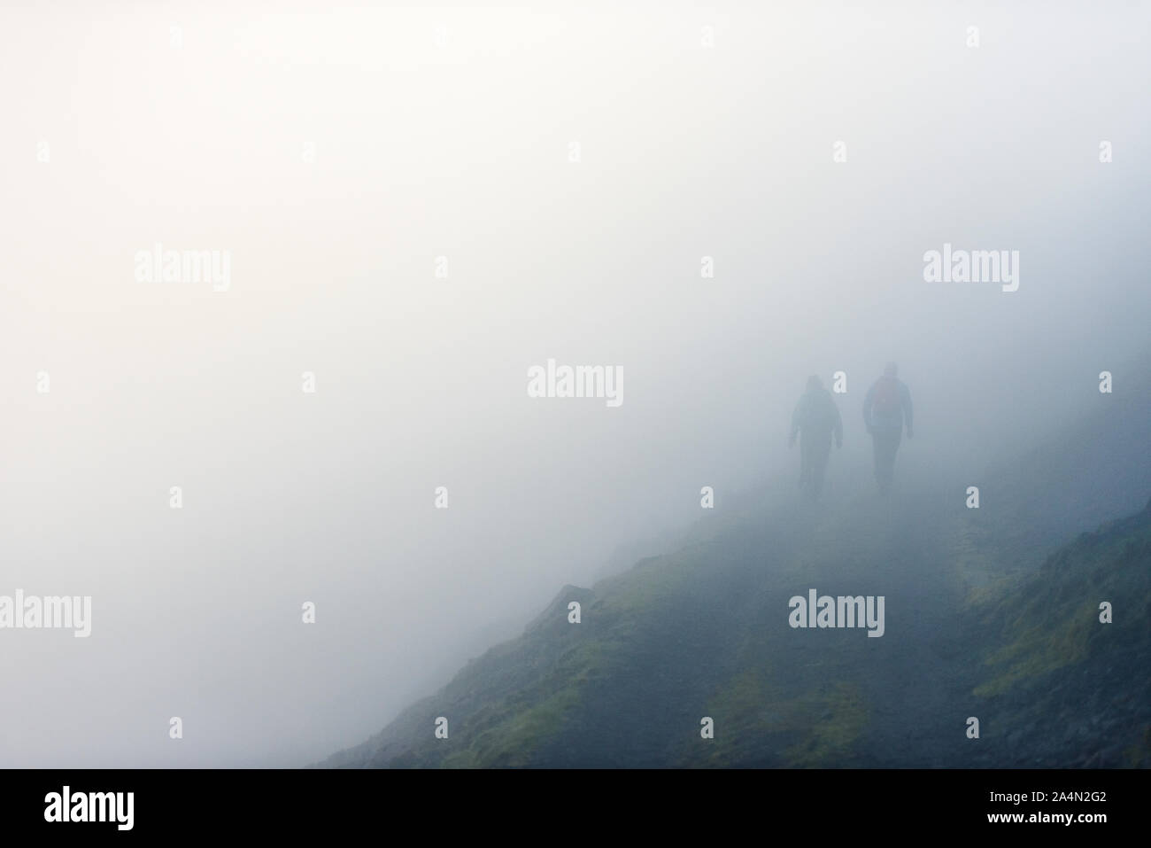 Silhouettes of hikers in fog Stock Photo