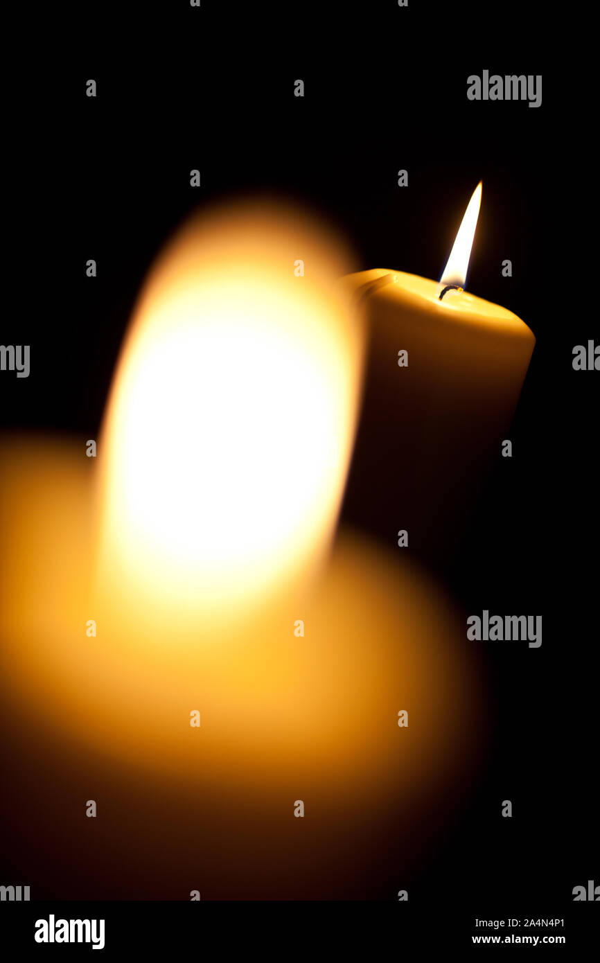 Two burning yellow candles on black background Stock Photo
