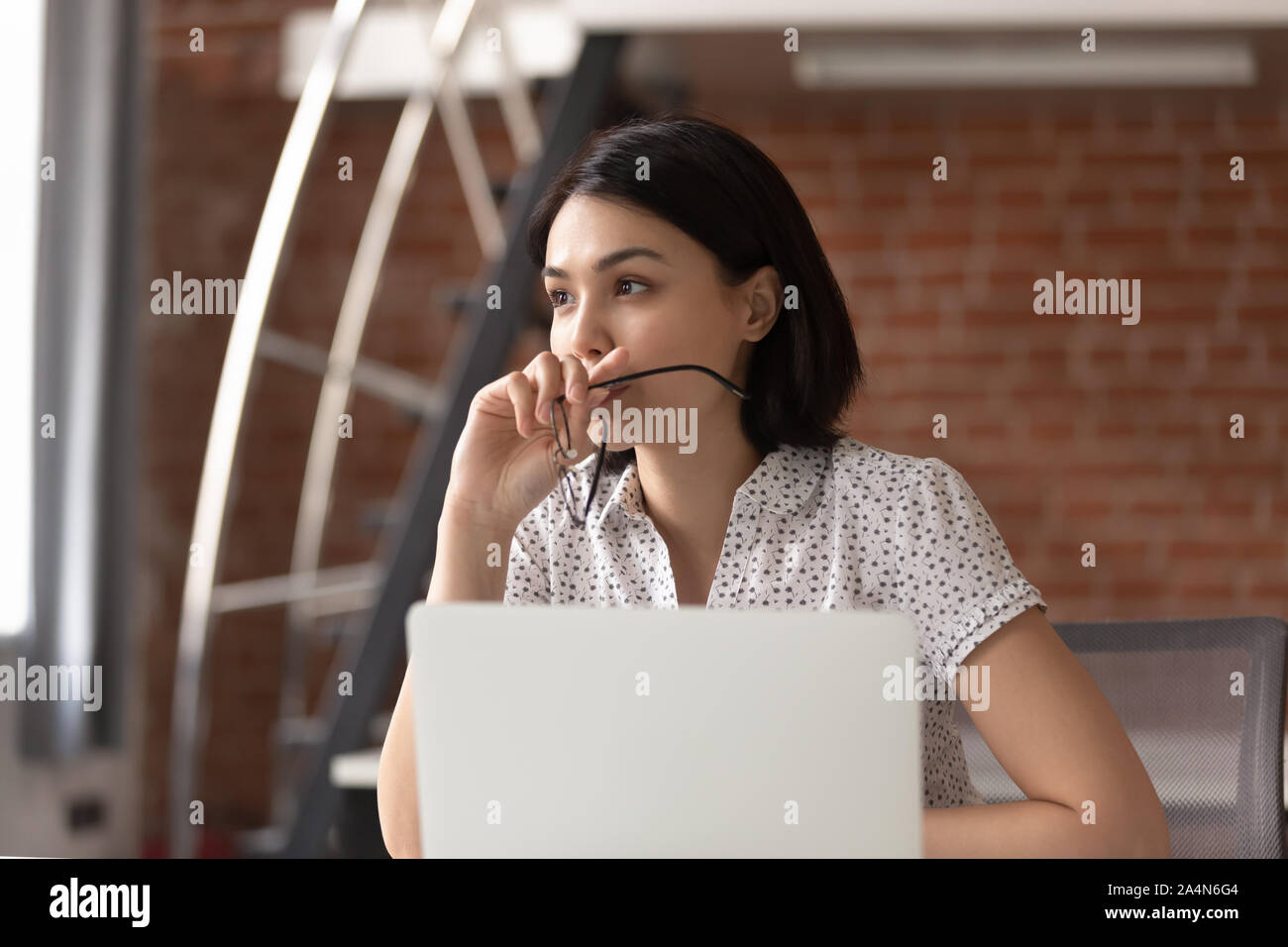 Thoughtful Asian businesswoman taking off glasses, pondering ideas Stock Photo