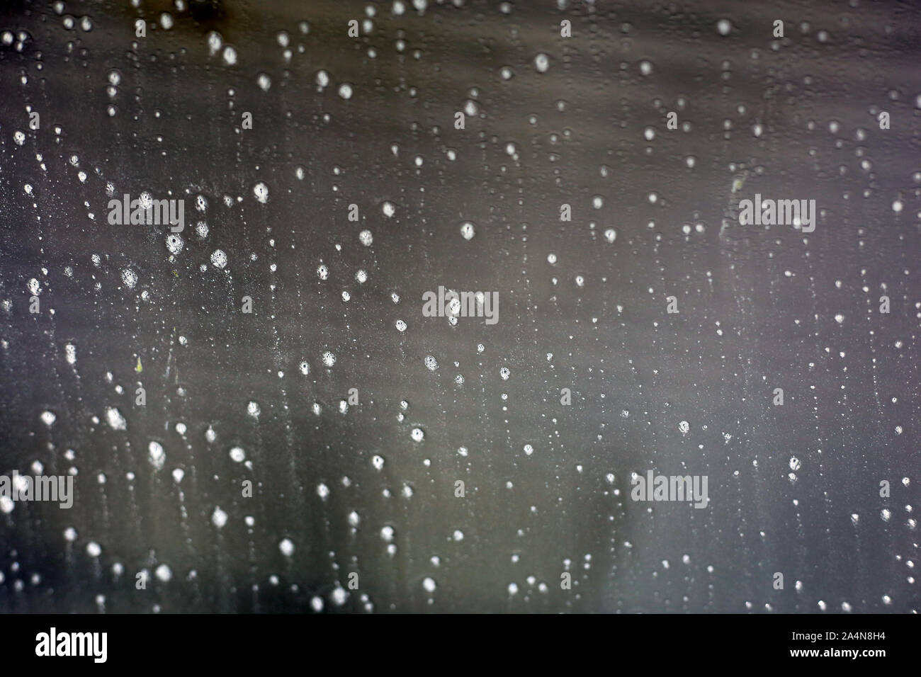 Inside a car washing machine - view to the wet window is abstract ...