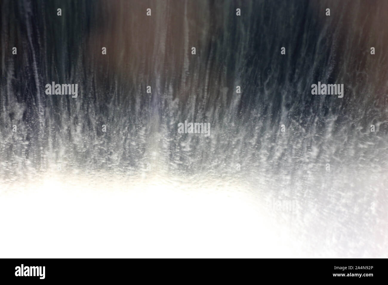 Inside a car washing machine - view to the wet window is abstract ...